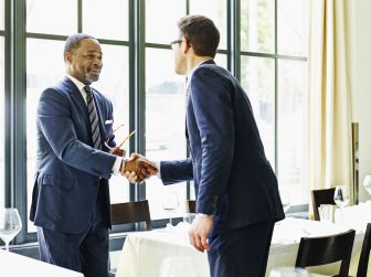 two-businessmen-shaking-hands-at-lunch-meeting-493585563-57717b175f9b585875c2d789